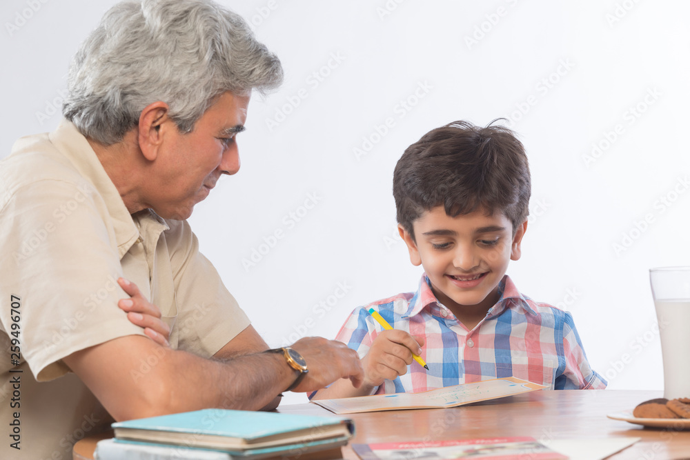 Grandfather helping grandson in homework 	