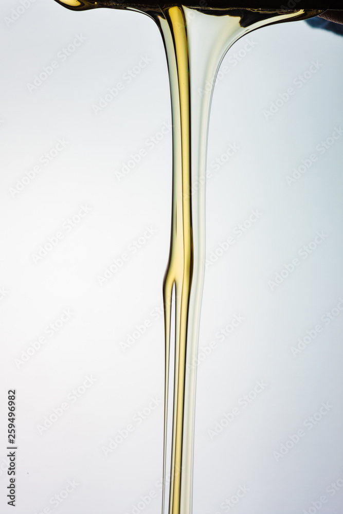 Pouring honey or golden liquid on white background. Pouring honey or golden liquid on white background.