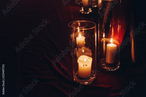 candles in glass lanterns, stylish wedding decor for evening wedding ceremony in garden, light close up. beautiful romantic place for love celebration