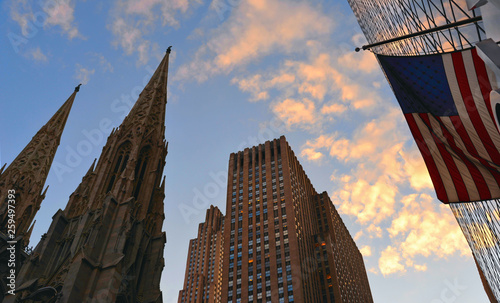 NEW YORK   View to the famous 5th avenue street with St. Patricks Cathedral, american flag, modern skyscrapers and old buildings in Midtown Manhattan  photo