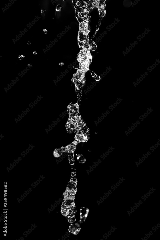 water jet with splashes on a black background water jet with splashes on a black background