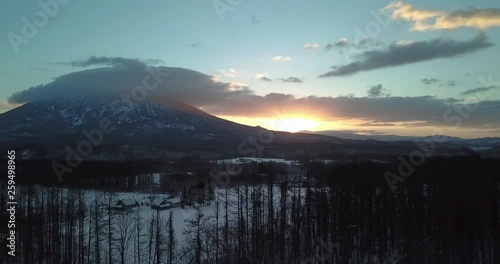 Aerial view of a large mountain sunrise in a snow covered landscape