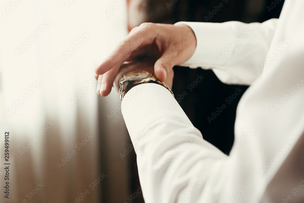 stylish groom dressing up, getting ready in morning for wedding ceremony, putting on golden watch stylish groom dressing up, getting ready in morning for wedding ceremony, putting on golden watch