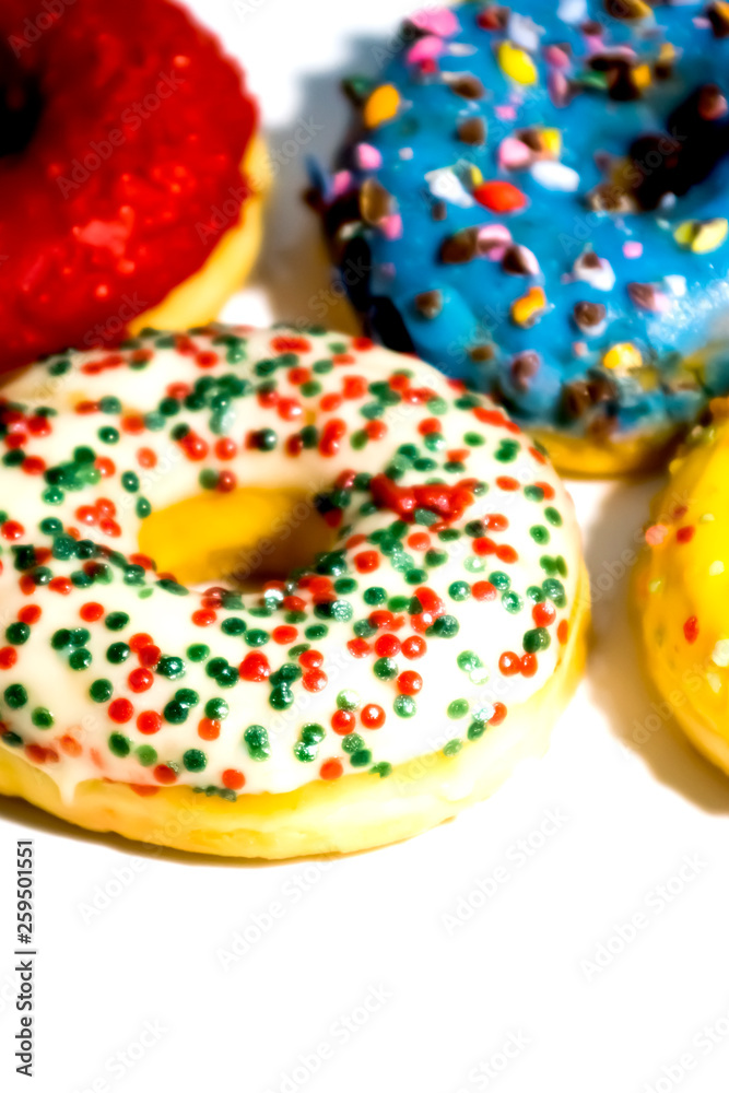 Sweet tasty donuts with colorful sprinkles isolated on white background