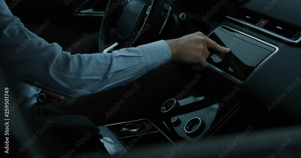 Slow motion close up of an young businessman driving a futuristic new technology car with augmented reality holographic display with modern assistance functions.