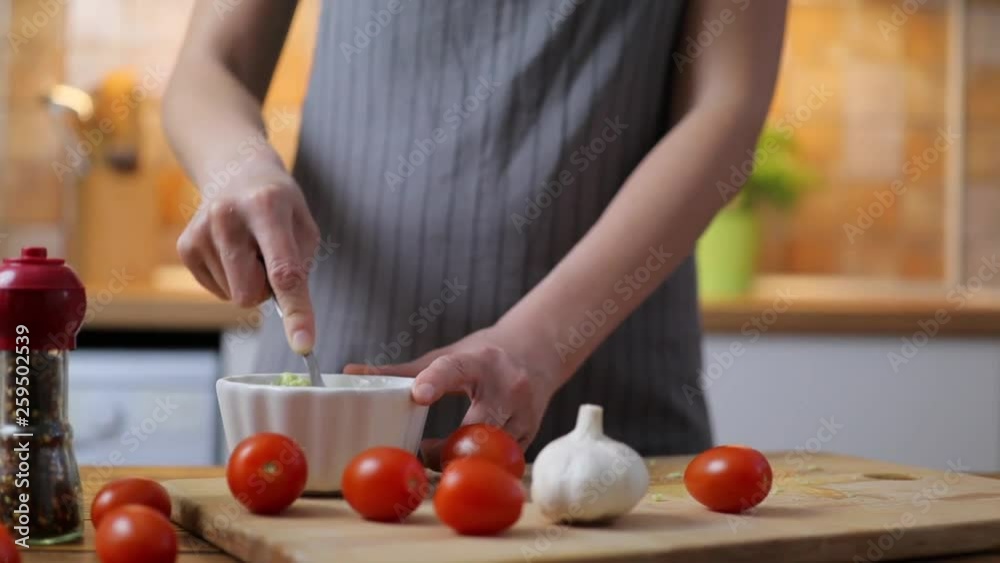 Woman making traditional Mexican sauce Guacamole from fresh ripe avocados. Woman making traditional Mexican sauce Guacamole from fresh ripe avocados.