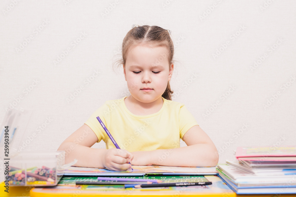 A little girl teaches lessons. Preparing for school. A little girl teaches lessons. Preparing for school.