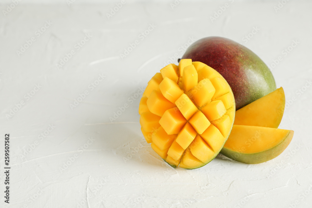 Cut ripe mangoes and space for text on white background, closeup