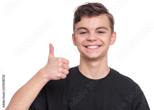 Handsome Teen Boy in black T-shirt making Thumb up Gesture. Portrait of caucasian Smiling Teenager isolated on white background. Happy child looking at camera.