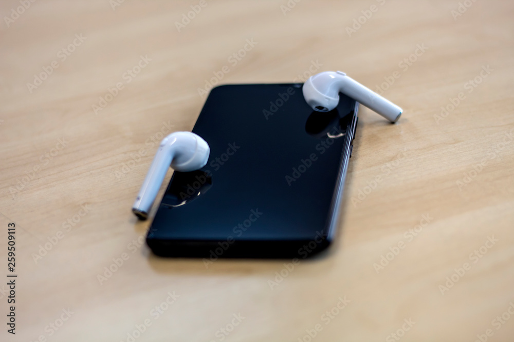 Smartphone with earphones on wood background Smartphone with earphones on wood background