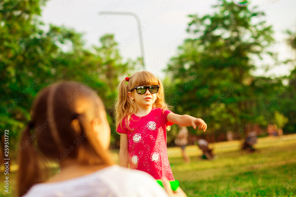 Naklejka premium Young mother and little daughter playing in park with soap bubbles. Love family, parenthood, childhood