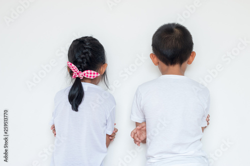 Boys and girls standing in front of the wall in the corner of the room.Because of being punished by parents.