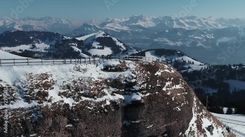 A Drone move along a cliff on a mountain with a fantastic scenic view to the swiss alps. photo