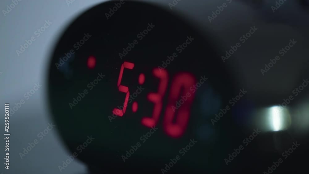 Close up shot of digital display on alarm clock flipping from 5:29 am to 5:30 am