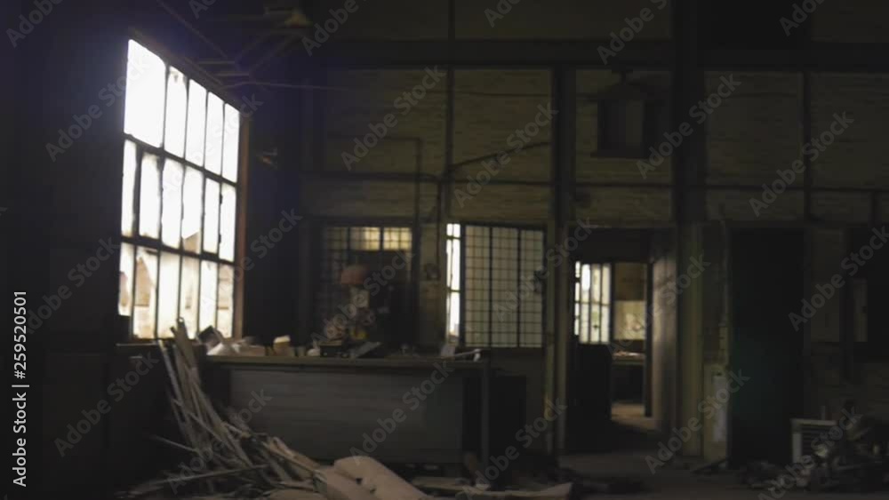 Inside look of a left behind factory facility. Industrial atmosphere, with broken windows, trash, dust and rust everywhere.