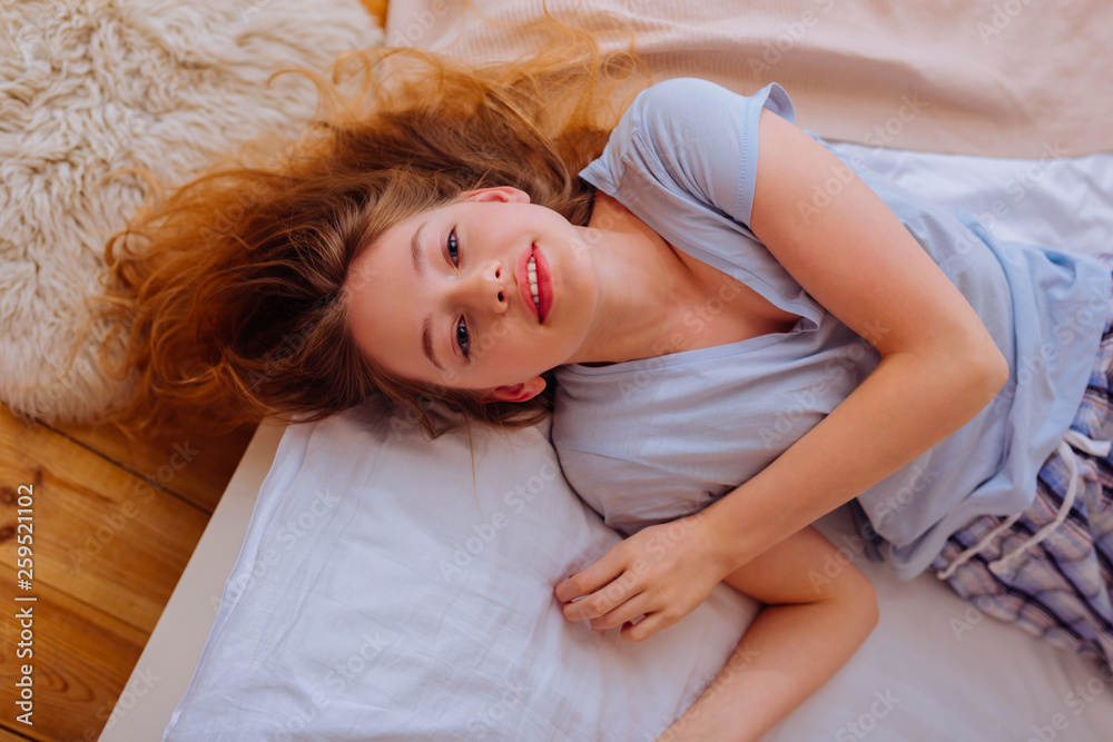 Naklejka premium Beautiful blue-eyed teenage girl chilling in the bedroom