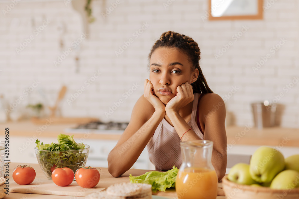Young slim woman feeling bored while spending morning alone Young slim woman feeling bored while spending morning alone