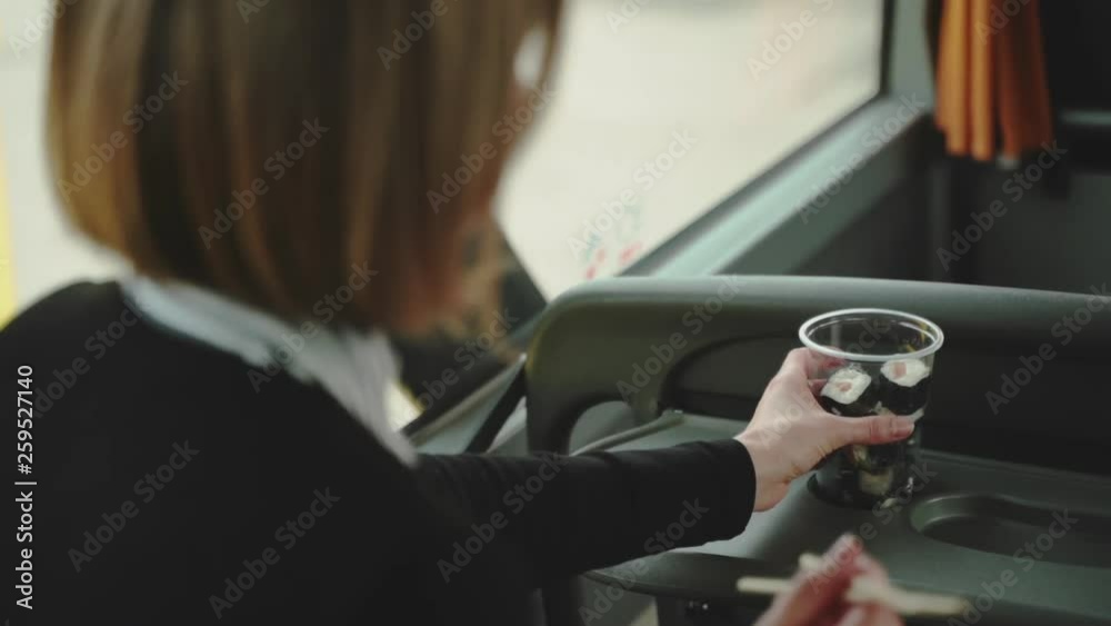 A Woman is Eating Sushi With Chopsticks on a Bus in Slow Motion. Over the shoulder A Woman is Eating Sushi With Chopsticks on a Bus in Slow Motion. Over the shoulder