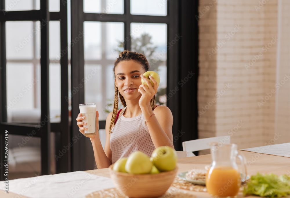Woman having healthy diet eating apple and drinking milk