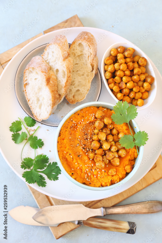 Vegetarian appetizer. Carrot and hummus dip and bread, sesame and chick-pea dressing Vegetarian appetizer. Carrot and hummus dip and bread, sesame and chick-pea dressing