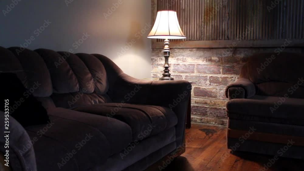 A living room with old brick, rustic metal and a lamp to light the dim room. A living room with old brick, rustic metal and a lamp to light the dim room.