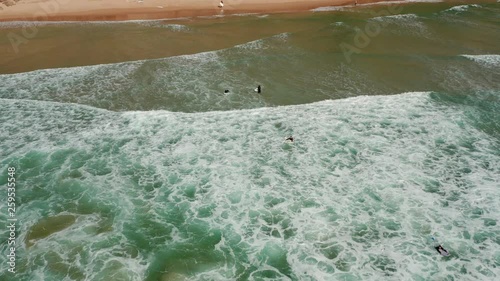 Aerial: Surfers at Sagres during a sunny day.