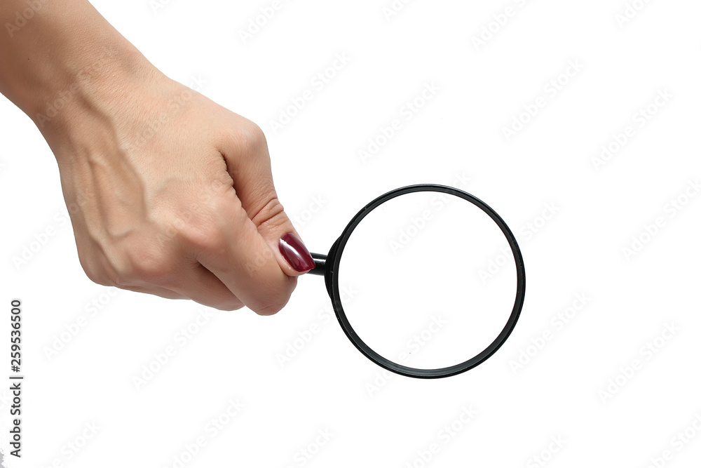 Female hand with a magnifying glass on a white background