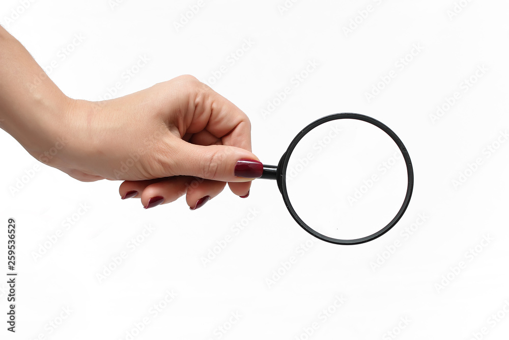 Female hand with a magnifying glass on a white background Female hand with a magnifying glass on a white background