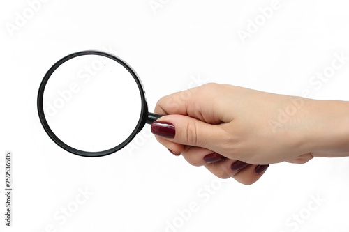 Female hand with a magnifying glass on a white background