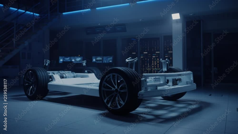 Concept of Authentic Electric Car Platform Chassis Prototype Standing in Industrial Machinery Design Laboratory. Hybrid Axel Frame include Wheels, Suspension, Engine, Brakes and Battery. 