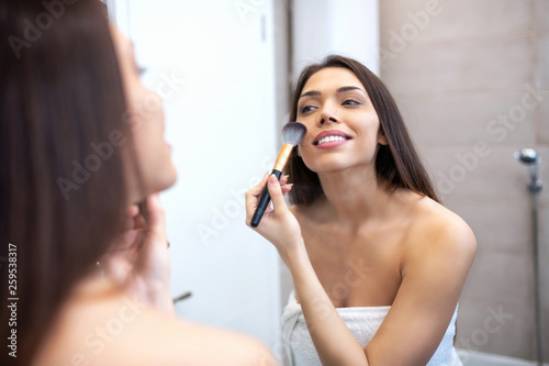 Applying gentle touches with a makeup brush