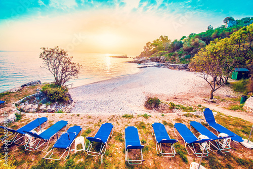 Fabulous beautiful magic dawn on Bataria Beach with sun beds for sunbathing on the coast of the Ionian Sea in Corfu (Керкіра), Greece. Amazing places. Tourist Attractions. photo