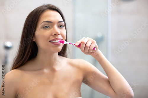 Attractive woman brushing her teeth