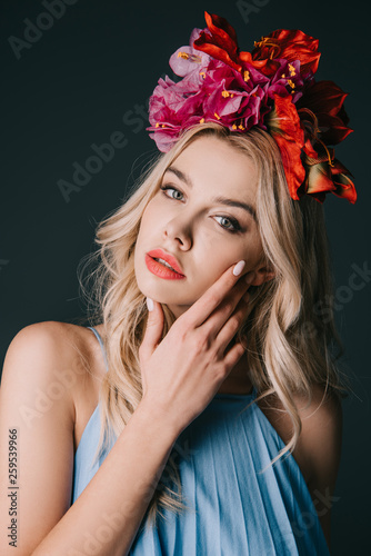 beautiful and blonde woman in wreath looking at camera isolated on black