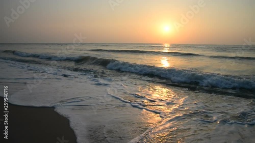 Wallpaper Mural Angled warm yellow ocean sunset view with waves rippling against the smooth shore and sun reflecting on water and sand Torontodigital.ca