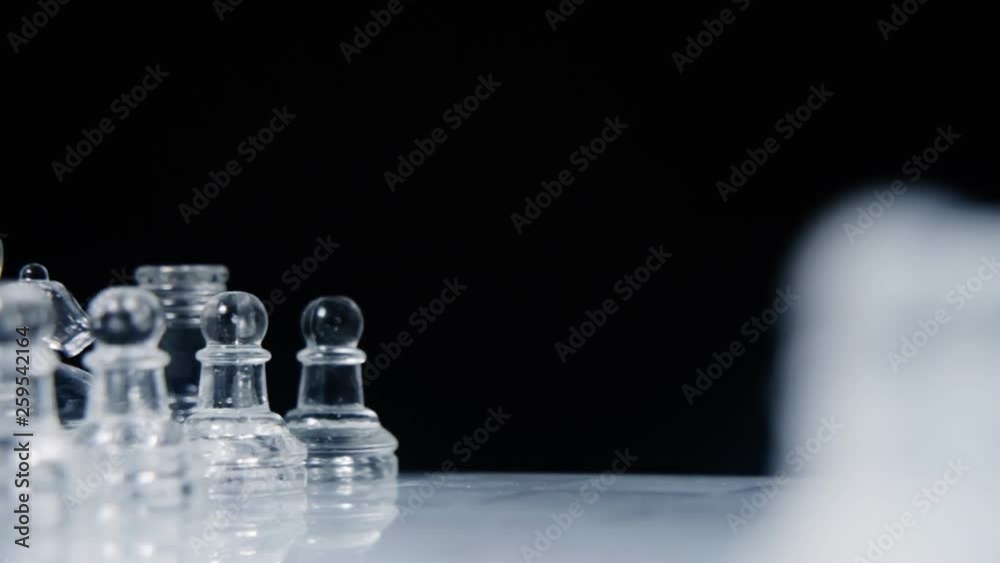 A gorgeous chessboard, with two different full sets of glass pieces, slowly rotating and revealing the other side as a blurred line-up.