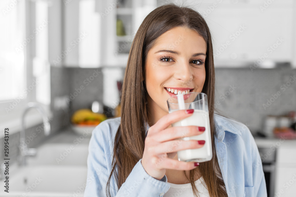 Close up of happy young woman drinking milk. - obrazy, fototapety, plakaty 