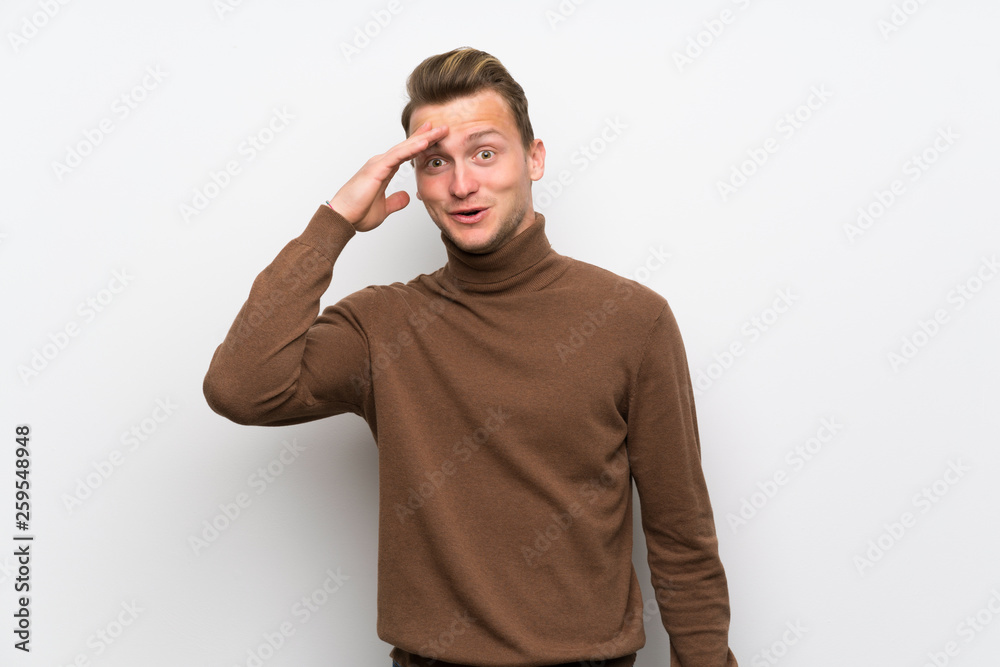 Blonde man over isolated white wall has just realized something and has intending the solution Blonde man over isolated white wall has just realized something and has intending the solution