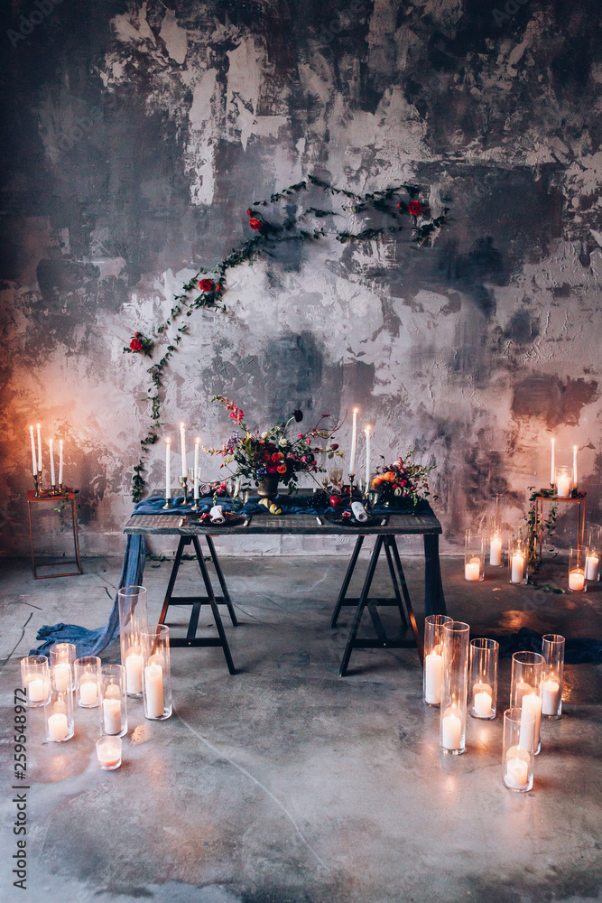 burning candles with bouquets of flowers on the table