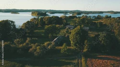 Aerial view of beautiful small village and lake with islands in background. Captured during sunset in Latvia. photo