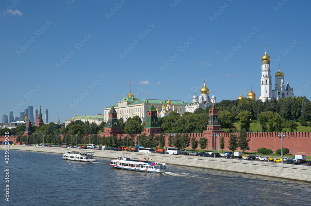 Summer view of the Moscow Kremlin, the Kremlin embankment and sailing pleasure boats. Moscow, Russia