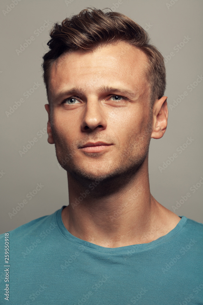 Male beauty, boy next door concept. Portrait of smiling and confused 30-year-old man standing over grey background. Close up. Classic style. Wavy glossy blond hair. Studio shot Male beauty, boy next door concept. Portrait of smiling and confused 30-year-old man standing over grey background. Close up. Classic style. Wavy glossy blond hair. Studio shot