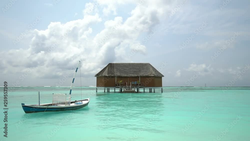 Vacation- Landscape view of beach with exotic wooden house (hut) with a boat on the seas. view of a beach,clouds beautiful sky . Vacation- Landscape view of beach with exotic wooden house (hut) with a boat on the seas. view of a beach,clouds beautiful sky .