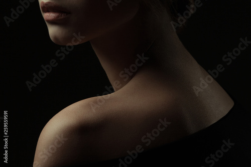 Natural beauty, purity concept. Old classic movies actress style. Close up profile portrait of gorgeous young woman with beautiful neck over black background. Studio shot