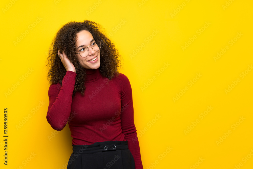 Dominican woman with turtleneck sweater thinking an idea while scratching head Dominican woman with turtleneck sweater thinking an idea while scratching head