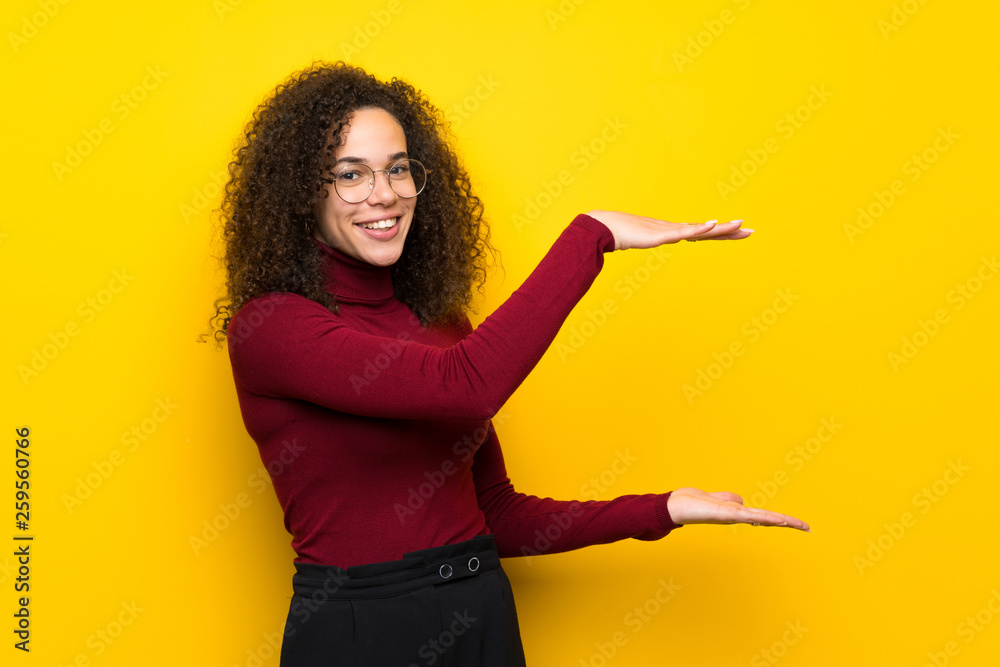 Dominican woman with turtleneck sweater holding copyspace to insert an ad Dominican woman with turtleneck sweater holding copyspace to insert an ad
