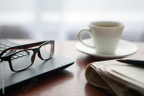 Newspaper with computer on table. Coffee break.