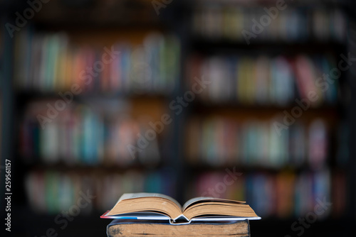 Book stack in the library room and blurred bookshelf for business and education background. School and university learning concept