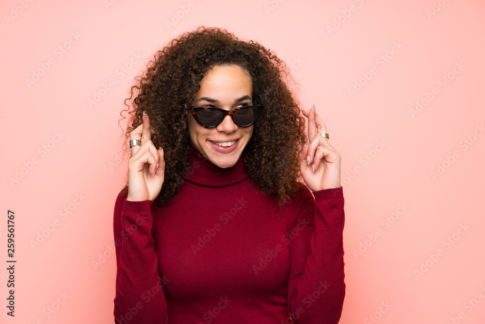 Dominican woman with turtleneck sweater with fingers crossing