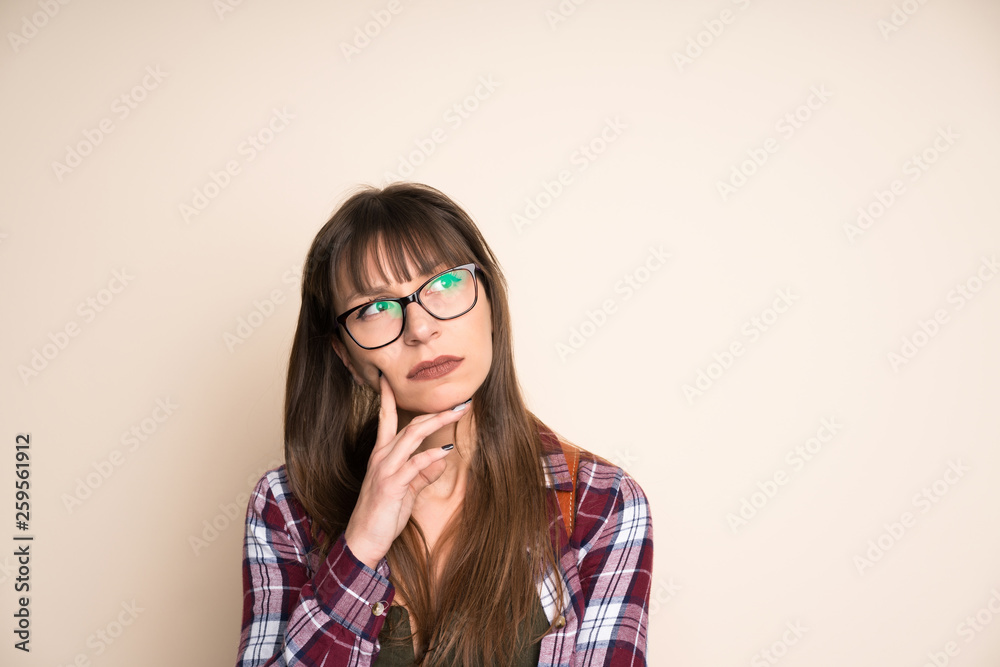Young woman on ocher background thinking an idea Young woman on ocher background thinking an idea